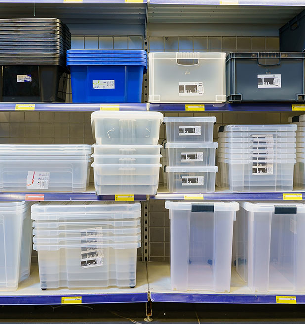 Contenedores de almacenamiento transparentes apilados sobre un estante en una tienda